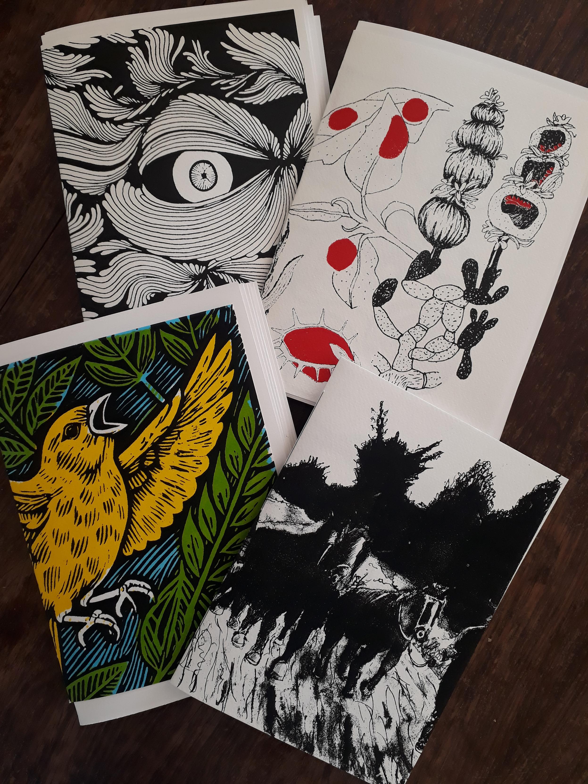Sur une table marron, 4 agendas sérigraphiés format A4 plié en deux, en papier blanc 220g.
Le premier en noir et blanc représente un oeil au milieu de sortes de plantes.
Le deuxième en noir, blanc et rouge représente des plantes qui ont une galle.
Le troisième en jeune, bleu, vert et noir représente un canari volant au coeur d'une forêt de feuilles.
Le quatrième représente un homme tirant deux chevaux de labour dans un pré, avec au loin des arbres.
