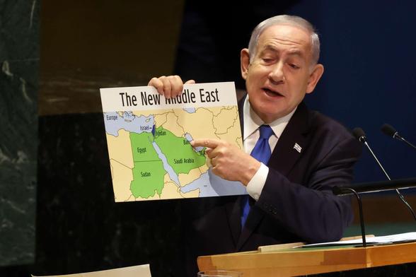 image of Netanyahu showing his New Middle East map at the United Nations in September 2023, a month before invading Gaza. the map shows an Israel with no Palestinian Territories and half of Lebanon gone.
