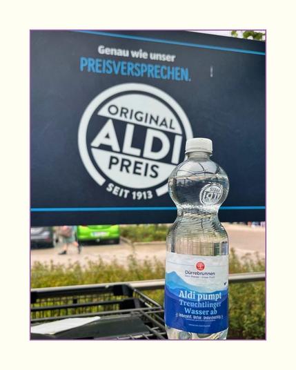 präparierte Wasserflasche von Altmühltaler vor Aldi-Werbetafel
