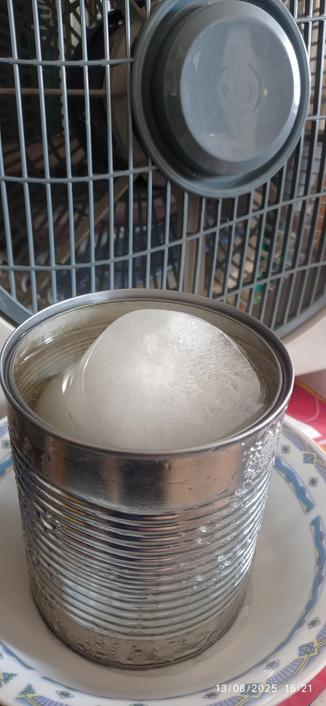 Ghiaccio in un barattolo di alluminio di fronte a un ventilatore. Il ghiaccio si sta già scioglidendo.