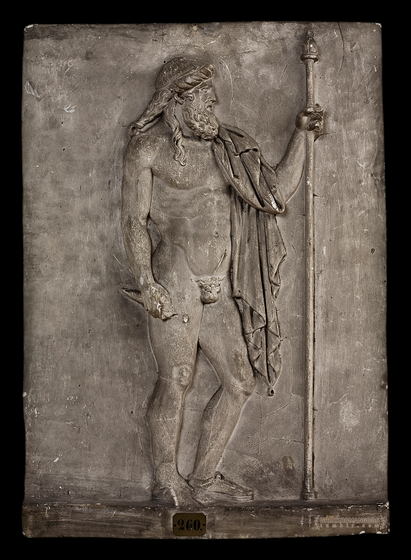 Relief of Zeus in heroic nudity, holding a sceptre in his left hand and a thunderbolt in his right. A himation is draped over hihs left shoulder and arm. His hair is braided in the front and falls loosely over his shoulders in the back. He is depicted as a mature man with a full beard.