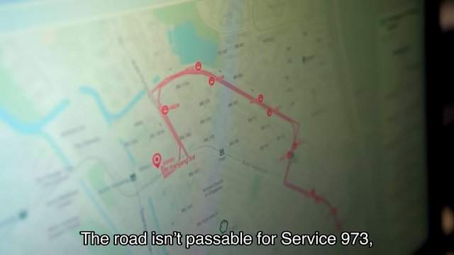 Map on a screen showing a route with bus stops marked, and a subtitle at the bottom reading "The road isn’t passable for Service 973,".