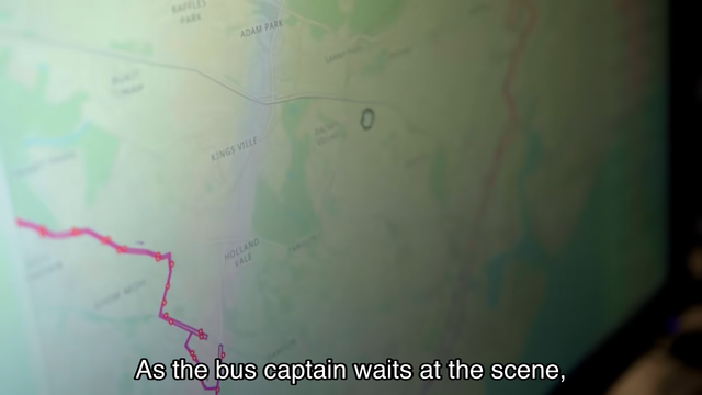 Map with location names and route lines displayed on a screen, with subtitles reading, "As the bus captain waits at the scene,".