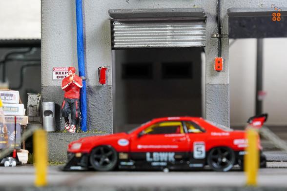 A focus shot on a guy with Nissan Skyline LB-ER34 Super Silhouette by Mini GT in 1:64 scale on AREA 164
