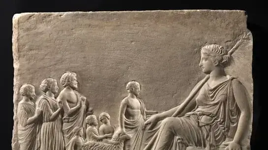 Relief depicting Aphrodite seated, holding a sceptre in her right arm. She wears a peplos. Seven smaller figures, her devotees, stand in front of her, four adults and three children with a sheep.