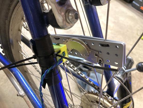 A magnet attached to some spokes of a bicycle wheel, with a 3D printed mount for a reed switch on the bike…