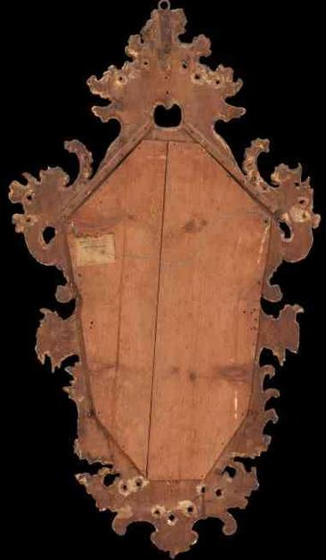 Back of an ornate, gilded rococo mirror frame with wooden backing.
