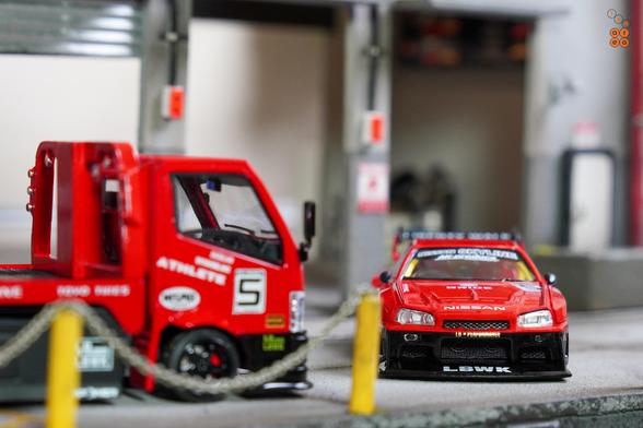 A Nissan Skyline LB-ER34 Super Silhouette by Mini GT and a Custom Tow Truck, LB Super Silhouette by Micro Turbo in 1:64 scale on AREA 164