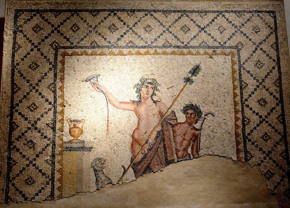 Dionysos, crowned with grapevine or ivy, his dark hair flowing to his shoulders, holds up a horn-like cup, pouring a libation. A leopard sits beneath it, looking up as if excited to taste the wine.