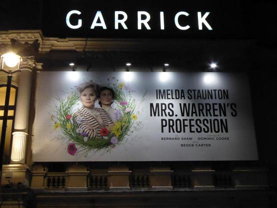 Photo of GARRICK in illuminated, white block capitals top with illuminated poster below, showing Imelda Staunton and Bessie Carter. Night.