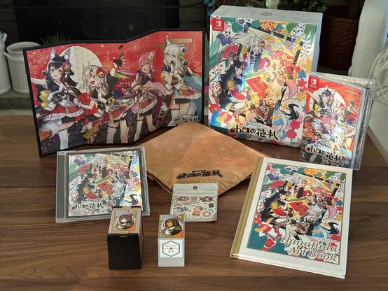 The contents of the Exclusive Hololive Edition of Holo’s Hanafuda for Nintendo Switch. There’s a large cardboard box with key art from the game on the front, a copy of the game for the Switch, a mini folding screen with the game’s four main members, a hardcover Hanafuda Art Book, a furoshiki with the game’s logo on it, some bento stickers, a copy of the soundtrack on CD, and a Hanafuda deck similar to Nintendo’s Napoleon deck but with Tokino Sora on the front instead. 
