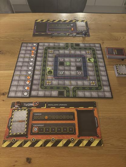 Der Spielaufbau: ein Parcours, der einer Fabrik aus Vogelperspektive nachempfunden ist. Vorne und hinten die Tableaus der Spieler mit den gewählten Roboterfiguren