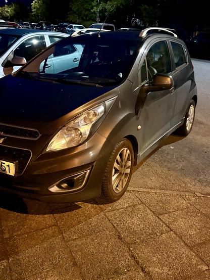 A car has its front wheel on the sidewalk despite being in a legal parking spot