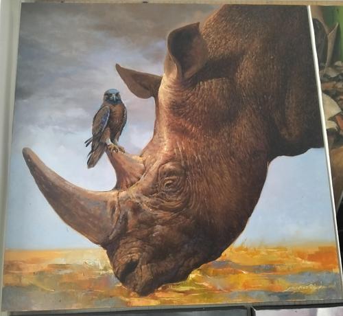 a painting of the side of a rhino's head, his two large horns sticking out, a small blue and brown hawk or falcon type bird is resting on his shorter horn, a grey cloud background, the earth gold colored 