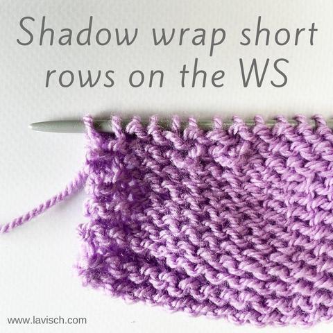 A swatch in lilac yarn on a gray knitting needle, in which several short rows with the shadow wrap method have been worked.