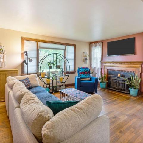 living room with tv, couch, fireplace, and wood floors.
