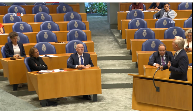 Van der Burg richt zich tot de oppositie achter hem, terwijl hij aan de interruptiemicrofoon staat