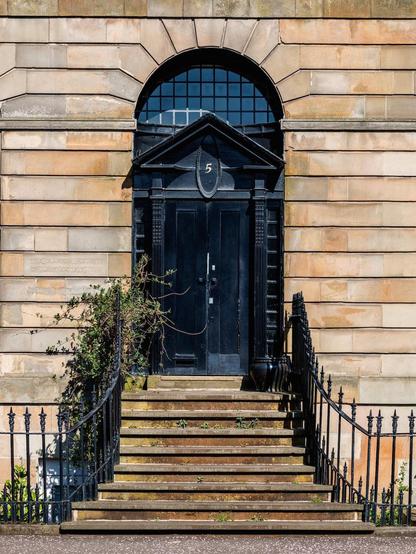 Red sandstone facade in Glasgow. Every detail of the entryway has been painted black.