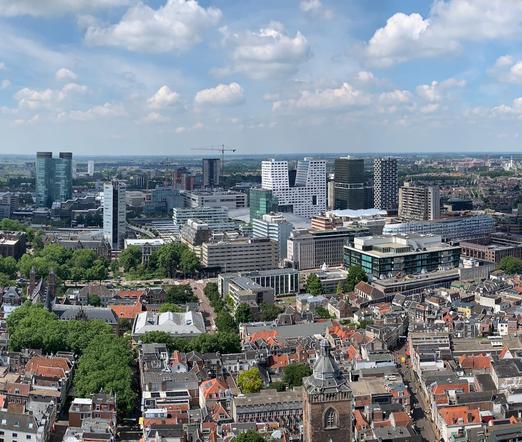 Zicht op gebouwen vanaf een hoog punt (Domtoren). Zelfde kant als andere foto, nu duidelijk meer hoogbouw.