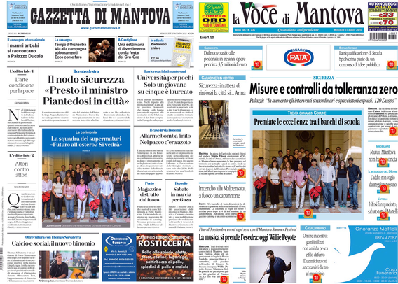 Una prima pagina di un giornale locale italiano intitolato "Gazzetta di Mantova" e "la Voce di Mantova". La parte superiore presenta i due titoli con un logo verde e giallo centrale e prezzi. La prima pagina è suddivisa in diverse colonne e articoli con titoli e foto. Alcuni titoli includono riferimenti a sicurezza ("Il nodo sicurezza", "Misure e controlli da tolleranza zero"), eventi locali ("Allarme bomba finito nel pacco cera azoto"), e iniziative scolastiche ("Premiate le eccellenze tra i banchi di scuola"), accompagnate da due foto di gruppo di giovani studenti. Ci sono annunci pubblicitari piccoli e tutti gli elementi sono organizzati in modo tipico di una pagina di giornale. 