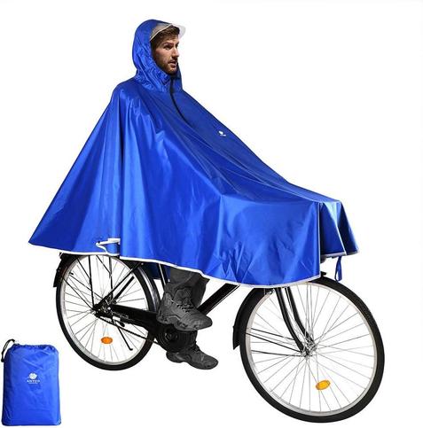 A man on a bike with a rain poncho made for cycling and it covers the handlebars and looks weird and wild. 