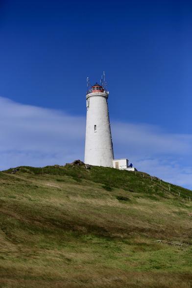 Reykjanesviti under a perfect sky with light clouds. This lighthouse, the oldest in Iceland, sits up top a hill