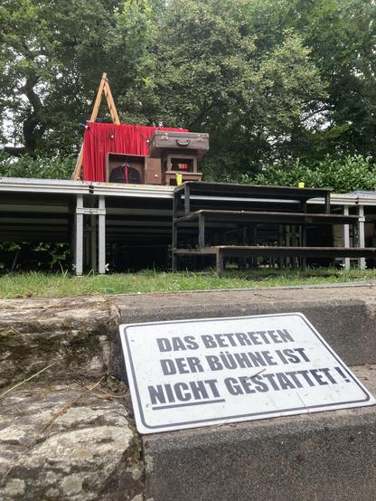 Auf einer Open Air Bühne sind unsere Requiten aufgebaut. Im Vordergrund ist ein altes Schild an den Treppenaufgang gelehnt. Darauf steht: Das Betreten der Bühne ist nicht gestattet. Das Wort NICHT ist dabei unterstrichen.
