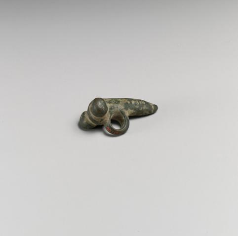 Phallus-shaped bronze amulet with two round testicles and a loop for a necklace dated to the 1st century CE.
Phallic emblems are found on a wide range of Roman objects, from amulets to frescoes to mosaics to lamps. They were symbols intended to bring good luck and ward off evil spirits. As the ancient author Pliny attests, even babies and soldiers wore such charms to invite divine protection.