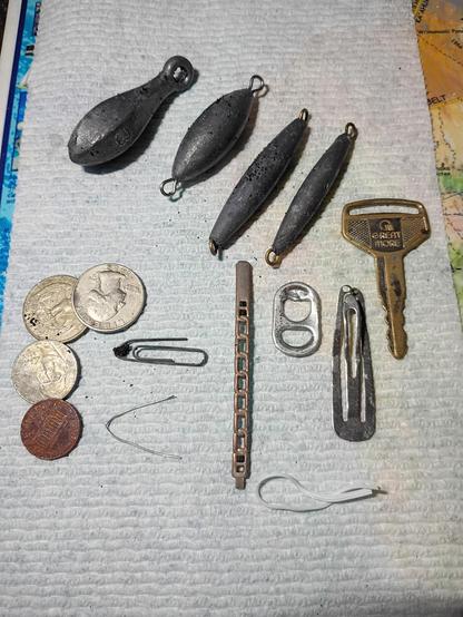 Metal detecting finds including lead fishing weights,coins a key and bits of random metal pieces.