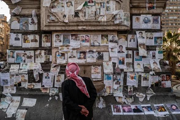 Les disparitions forcées, la tragédie oubliée du conflit Syrien. Un homme regarde des photos de disparus affichées sur un mur.