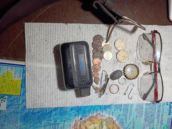 Metal detecting finds including glasses,vape,coins,fish hooks, fishing sinker, bottle cap and a leather belt with metal buckle