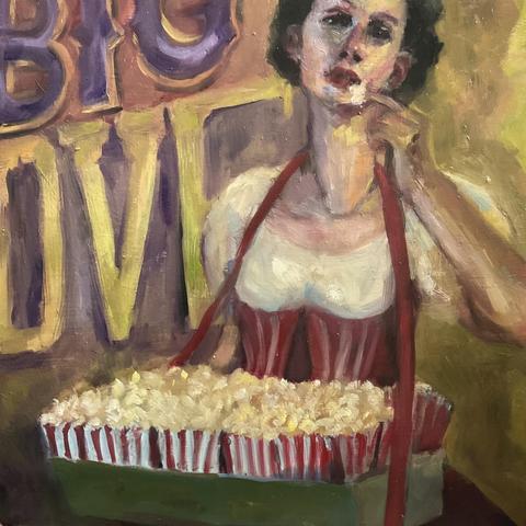A white woman with dark hair dressed as a theatre popcorn seller, carrying a box of popcorn, looking direct at viewer, about to eat a piece of popcorn. Behind and top left corner are the words Big Love in circus style script, but the L and E are mostly obscured at top part of Big at top. Colors are purple, acid green, red & white. 