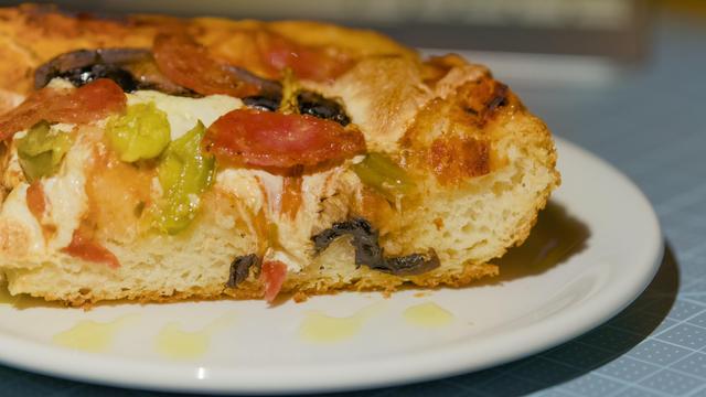 Focaccia pizza from the side. Close-up of salami.