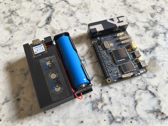 A Particle Tachyon single board computer next to a 3d printed prototype which houses some magnets, an 18650 battery, and a seeed xiao sense ble dev board.