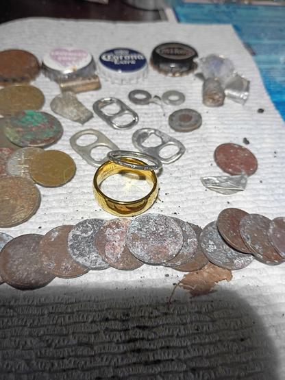 Metal detecting finds including a gold plated tungsten ring and a silver Pandora ring with stones. Lots of crusty coins and bottle caps.