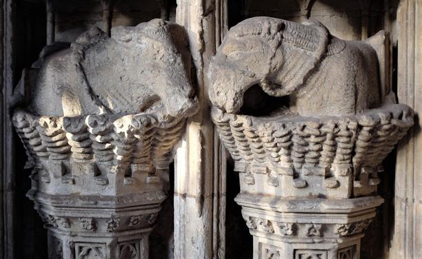 A carving in stone, depicting an ox and an ass in wickerwork stalls. The animals are turned to each other in an affectionate manner. The ox has a yoke around its neck and the ass a bridle. 
