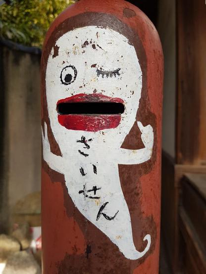 Worshippers slip coins into the mouth of this ghost, an unusual offertory box across the road from our teahouse.