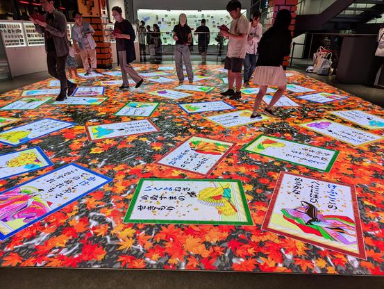 An interactive Hyakunin Isshu Karuta style game. Participants use a handheld device and match cards shown with those on the display floor.