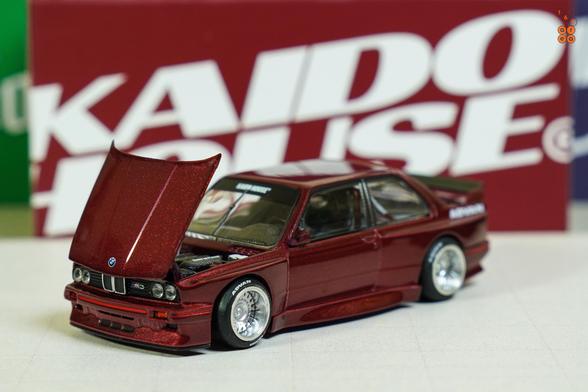 A left side of BMW M3 E30, Kaido Works GT V1, Calypso Red Metallic by Mini GT in 1:64 scale on AREA 164