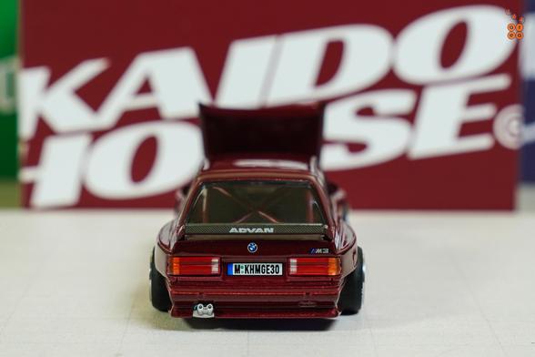A rear side of BMW M3 E30, Kaido Works GT V1, Calypso Red Metallic by Mini GT in 1:64 scale on AREA 164
