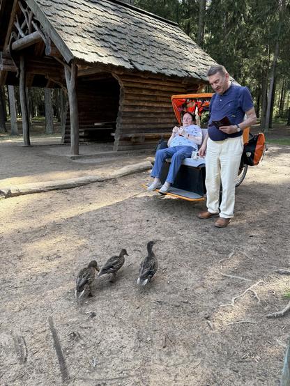 Enten an der Rikscha mit einer Passagierin und ihrem davor stehenden Mann