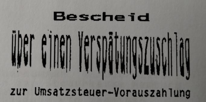 Ein "Bescheid über einen Verspätungszuschlag zur Umsatzsteuer-Vorauszahlung“. Allerdings ist „über einen Verspätungszuschlag“ durch einen Kopier- oder Scanfehler grotesk verzerrt. Die Buchstaben sind in die Länge gezogen und wirken unheimlich.