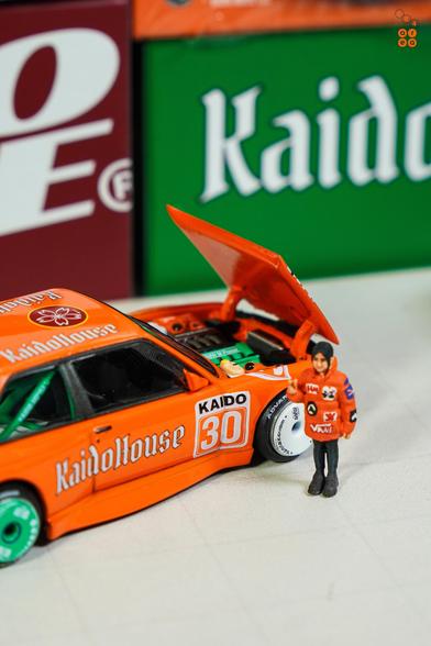 A BMW M3 E30, KaidoHaus V1 by Mini GT in 1:64 scale with 1:64 figure on AREA 164