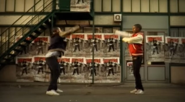 Two men in the dance battle in on the pavement.