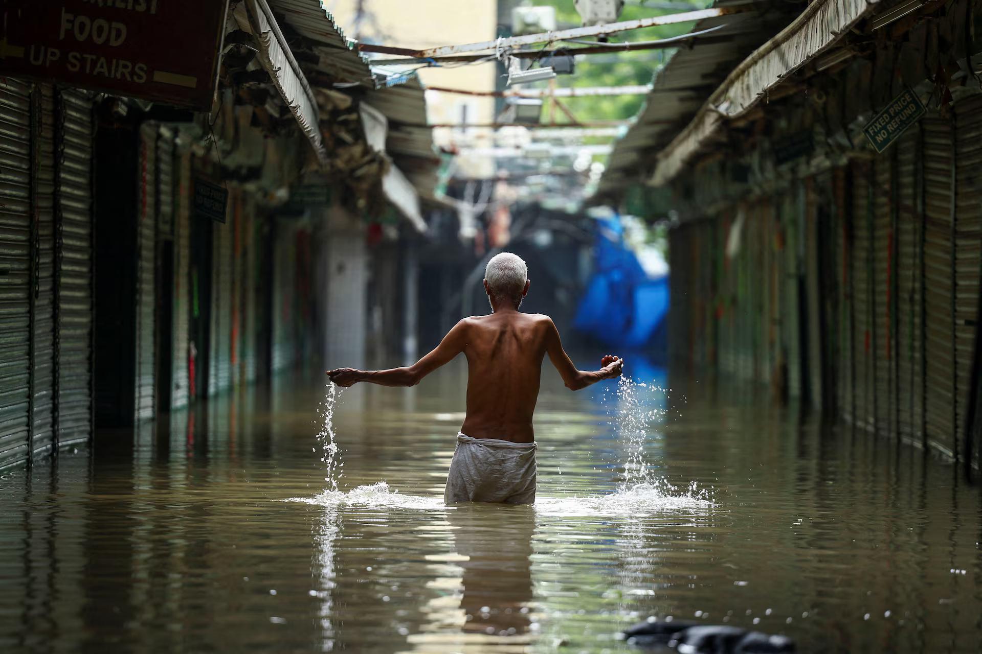 A man walks through a flooded market. A man walks through a flooded market.