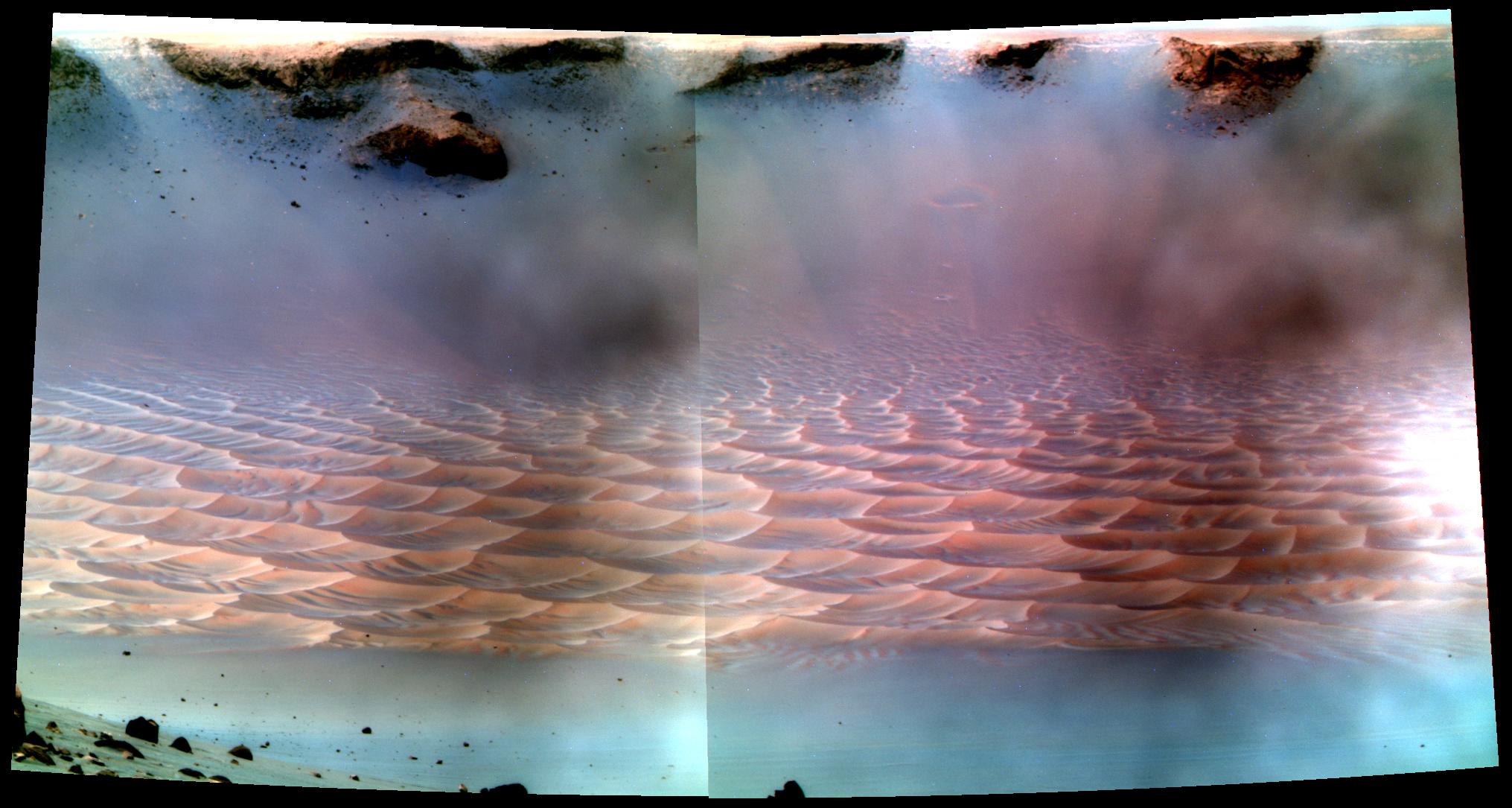 This mosaic was acquired by the Mars Exploration Rover Opportunity on Sol 1437 (February 8, 2008). The view of dunes and ripples inside Victoria Crater was shot while the rover examined the target Buckland with instruments on its robotic arm. Particles from the martian dust storm of mid-2007 are still visible on the camera's optics. Pancam's 753nm, 535nm, and 432nm filters were used in this mosaic. This version of the mosaic is a false color stretch to enhance the subtle color differences in the scene.
Image credit: NASA/JPL/Cornell; Image mosaicking: Elaina McCartney, Jon Beans Proton, Jonathan Joseph; Calibration and color rendering: CCC and the Pancam team (Jim Bell) This mosaic was acquired by the Mars Exploration Rover Opportunity on Sol 1437 (February 8, 2008). The view of dunes and ripples inside Victoria Crater was shot while the rover examined the target Buckland with instruments on its robotic arm. Particles from the martian dust storm of mid-2007 are still visible on the camera's optics. Pancam's 753nm, 535nm, and 432nm filters were used in this mosaic. This version of the mosaic is a false color stretch to enhance the subtle color differences in the scene.
Image credit: NASA/JPL/Cornell; Image mosaicking: Elaina McCartney, Jon Beans Proton, Jonathan Joseph; Calibration and color rendering: CCC and the Pancam team (Jim Bell)