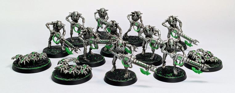 Necron Warriors and Canoptek Scarab Swarms in a light silver color with neon green highlights.