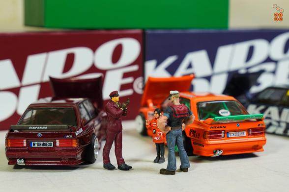 People and BMW M3 E30, Kaido Works cars by Mini GT in 1:64 scale with 1:64 figures on AREA 164