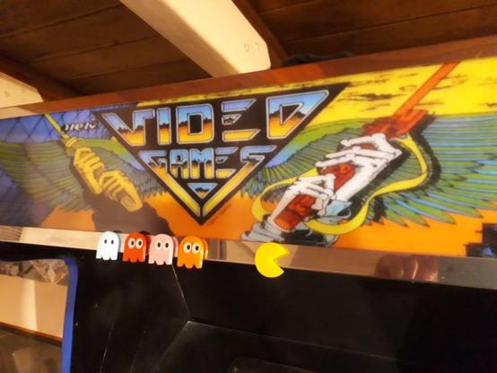 La imagen es un primer plano de la marquesina de mi arcade multijuegos. Agregado de guardas de acero inoxidable, con el detalle de imanes impresos 3d de los fantasmas pacaman persigueindo al susodicho.