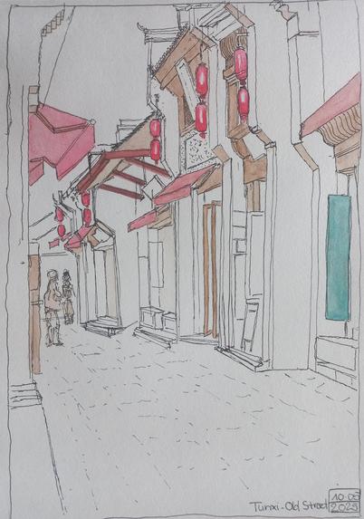 Aquarelle d'une vieille rue pavée et des devantures de magasin qui s'enchaînent en perspective, des auvents, des balcons et des stores et lampions rouges.
Watercolour of an old cobbled street with a row of shops with their red awnings and typical chinese lanterns.